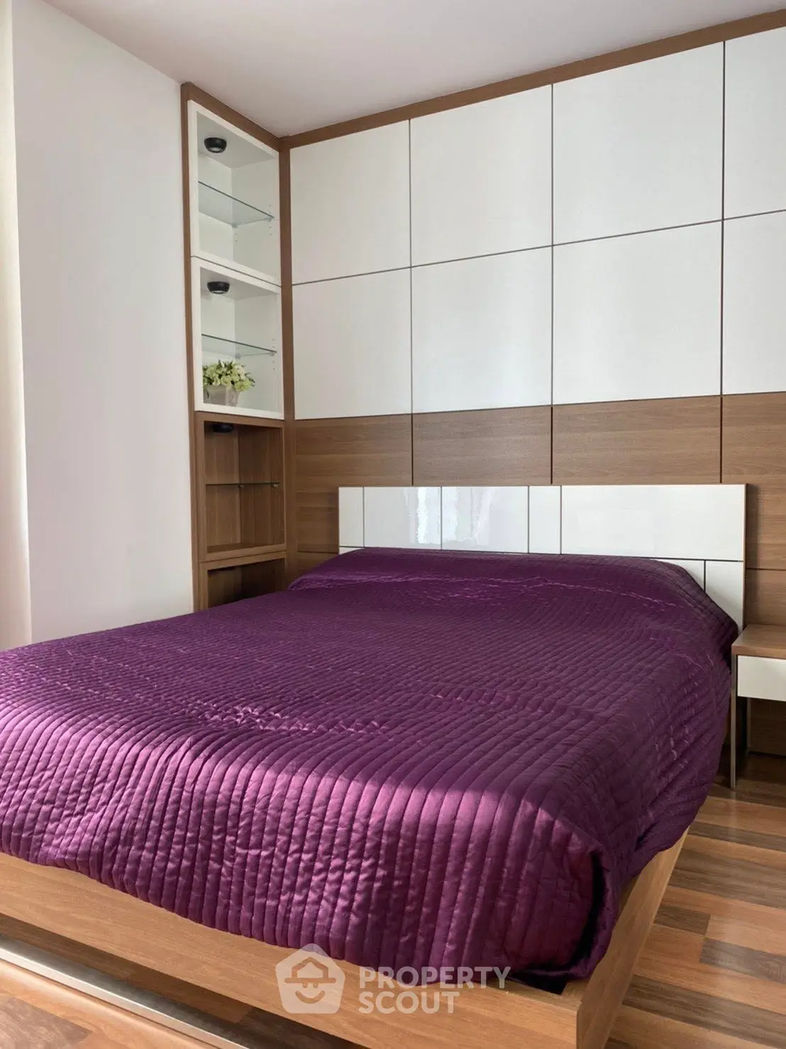 Modern bedroom with stylish wood paneling and purple bedding