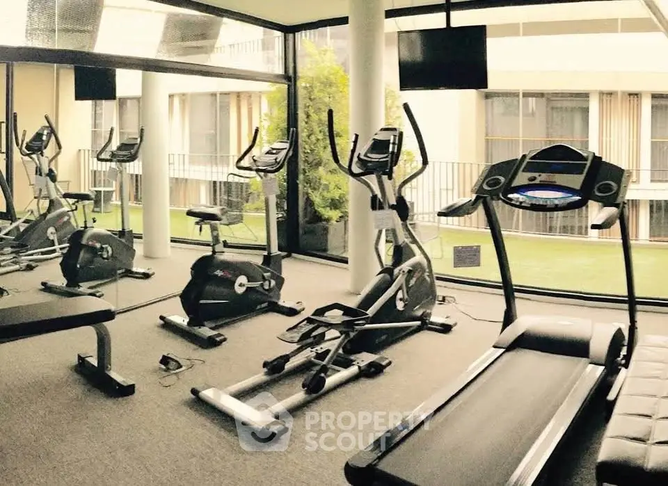 Modern gym with state-of-the-art equipment and large windows offering a scenic view.
