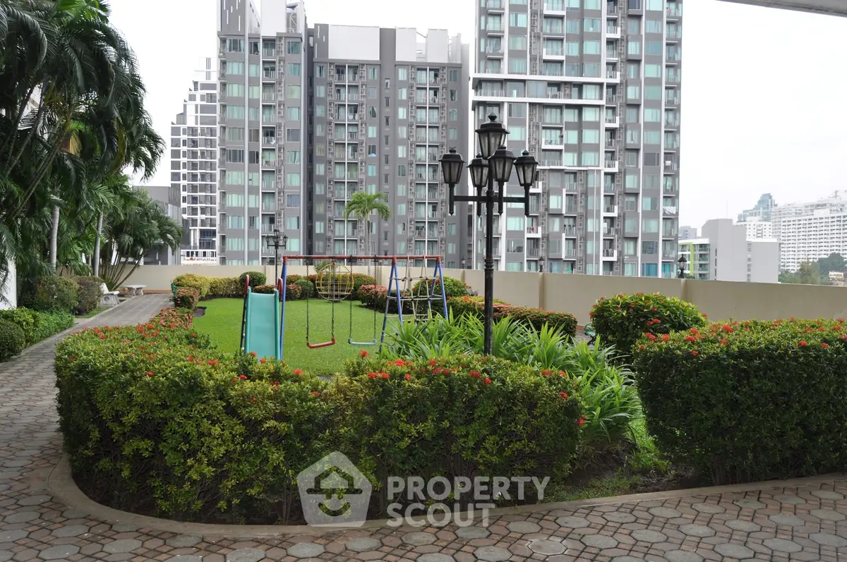 Modern residential complex with lush garden and playground area, ideal for family living.