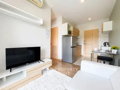 Modern living room with open kitchen and sleek furniture in a cozy apartment.