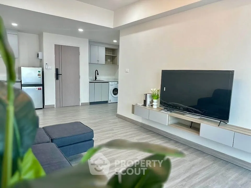 Modern living room with sleek design and integrated kitchen appliances