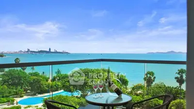Stunning ocean view from a balcony with seating and wine setup, perfect for relaxation.