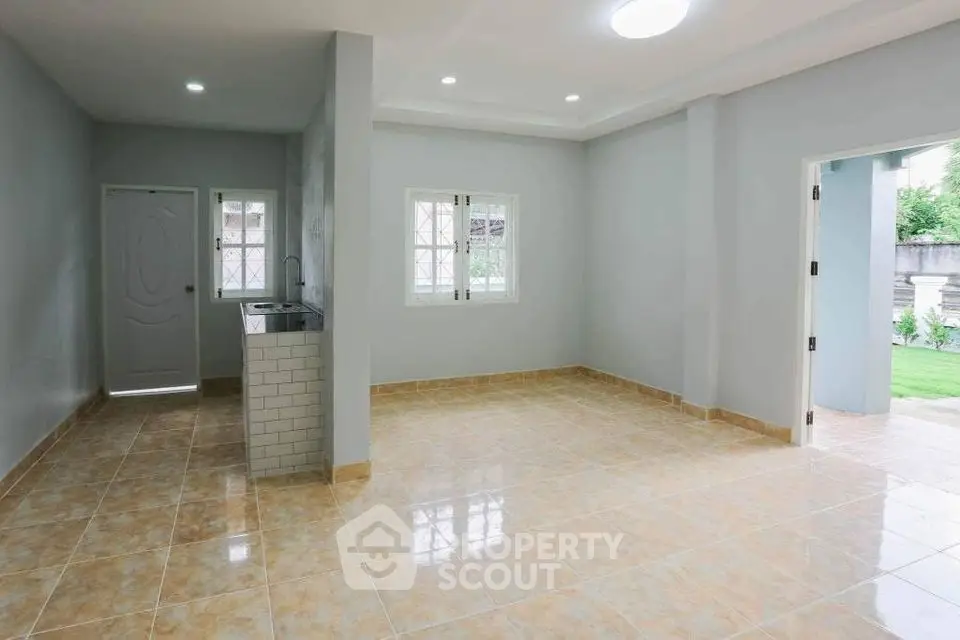 Spacious open-plan living area with tiled flooring and ample natural light.