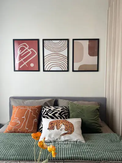 Stylish bedroom with modern art and cozy pillows, perfect for relaxation.