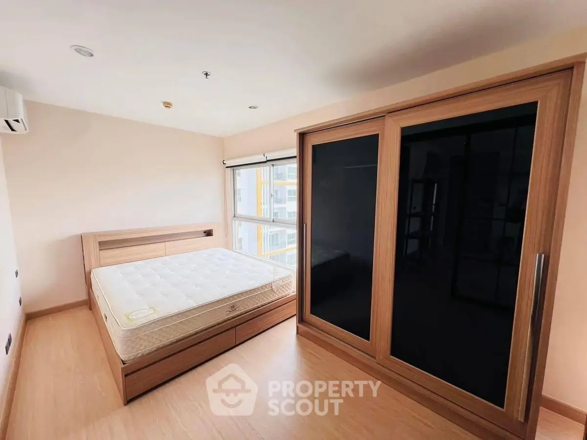 Spacious bedroom with large wardrobe and natural light in modern apartment