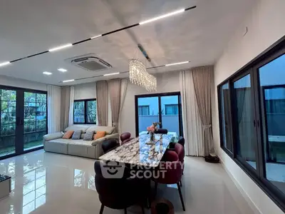 Luxurious modern living room with elegant marble dining table and large windows overlooking garden.