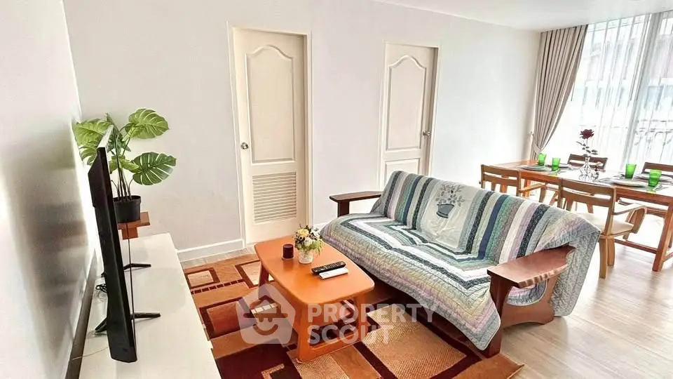 Charming living room with cozy sofa, modern TV setup, and elegant dining area, perfect for relaxation and entertaining.