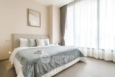 Bright and airy bedroom with large windows and modern decor in a stylish apartment.