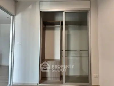 Spacious modern closet with sliding doors in a minimalist bedroom setting.