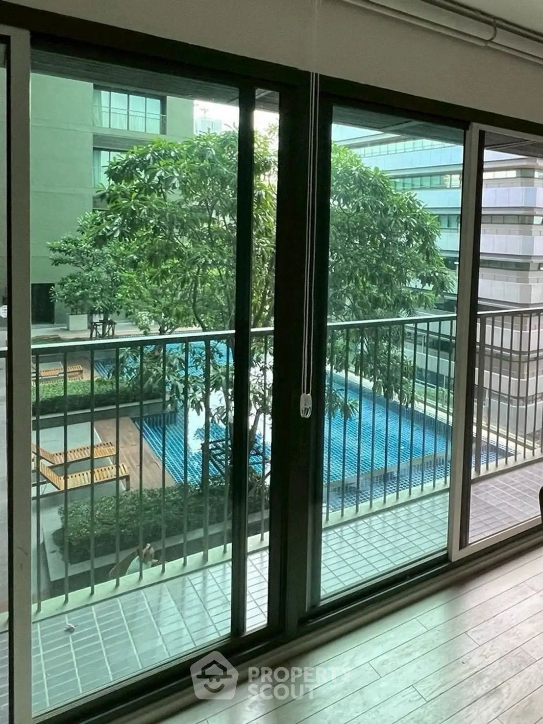 Spacious balcony with pool view in modern apartment complex
