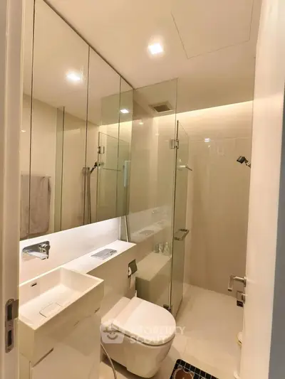 Modern bathroom with glass shower and sleek fixtures in a contemporary apartment.