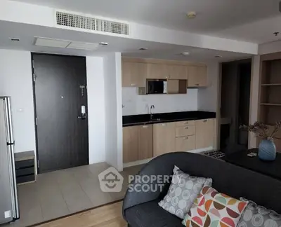 Modern open-layout kitchen and living room with stylish decor and ample natural light.