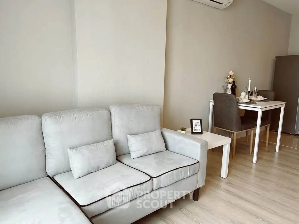 Modern living room with cozy sofa and dining area in open layout apartment.