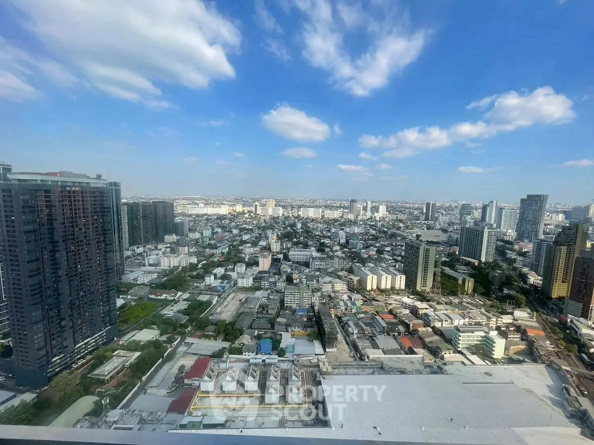 Stunning panoramic cityscape view from a high-rise building, showcasing urban skyline and clear blue skies.