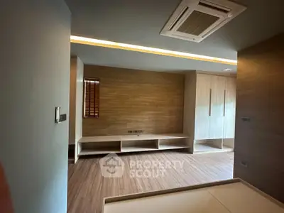 Modern minimalist bedroom with wooden flooring and built-in storage