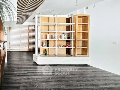 Modern living room with stylish wooden shelving and dark flooring