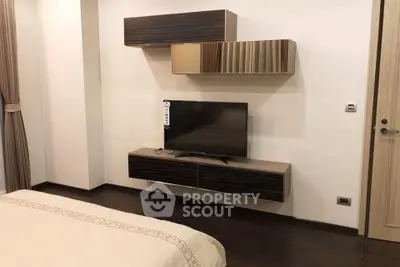 Modern bedroom with sleek wall-mounted TV and stylish storage units.
