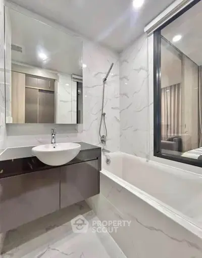 Modern bathroom with sleek design, featuring a bathtub and stylish vanity in a contemporary apartment.