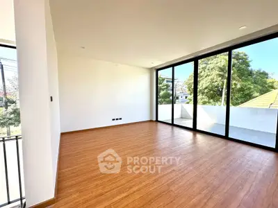 Spacious modern living room with large windows and balcony access