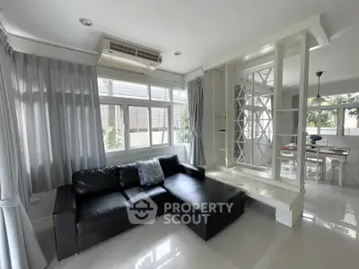 Spacious living room with modern black sofa and large windows for natural light