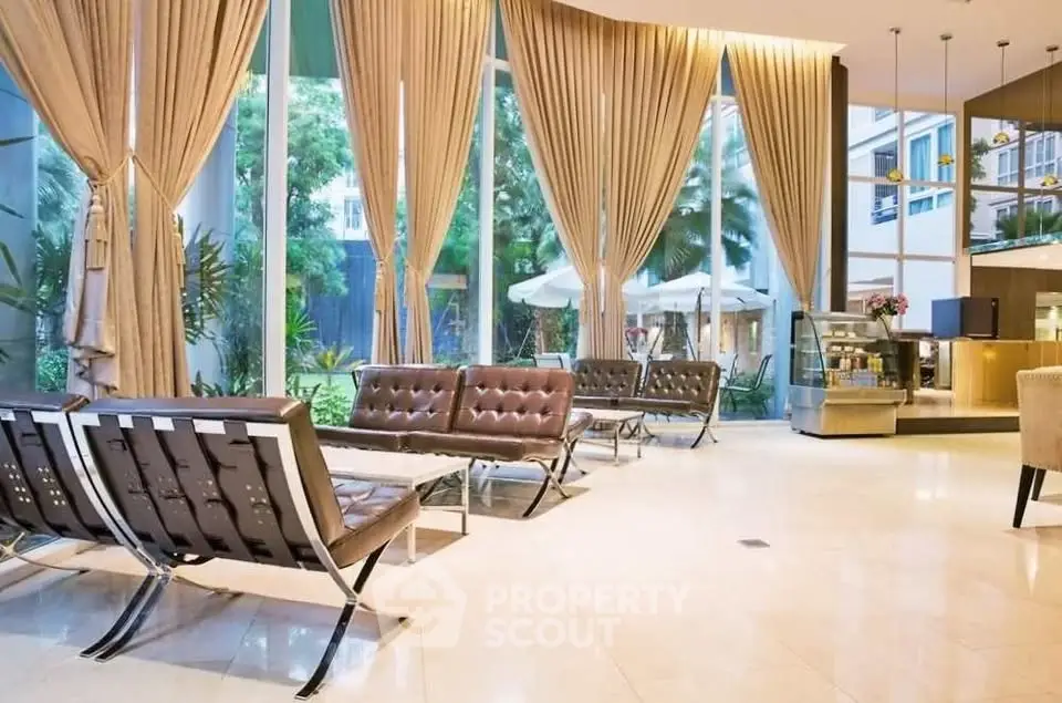 Luxurious lobby with modern seating and floor-to-ceiling windows overlooking lush greenery.