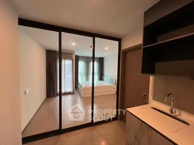 Modern apartment interior with glass partition and sleek kitchen area