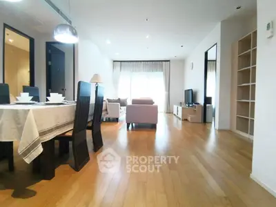 Spacious modern living room with elegant dining area and natural light.