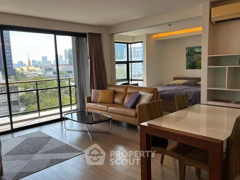 Spacious open-plan living room with city view and modern furnishings in a stylish apartment.
