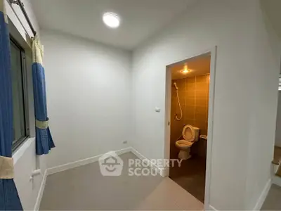 Compact room with attached bathroom, featuring tiled flooring and modern lighting.