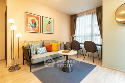 Modern living room with stylish decor and natural light, featuring a cozy sofa and chic artwork.