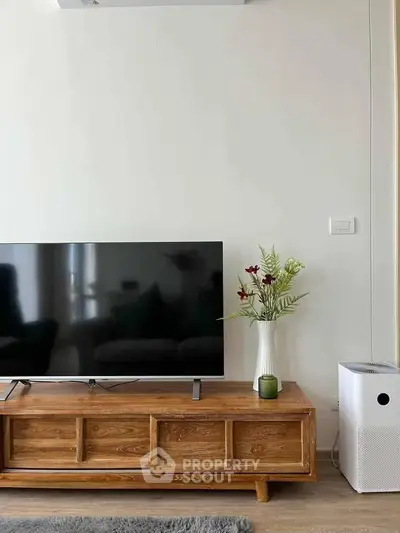 Modern living room with sleek TV stand, large flat-screen TV, and stylish decor accents.