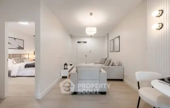 Modern living room with elegant decor and cozy seating, adjacent to a stylish bedroom, perfect for urban living.