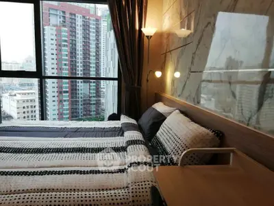 Modern bedroom with city view, featuring stylish decor and large window for natural light.