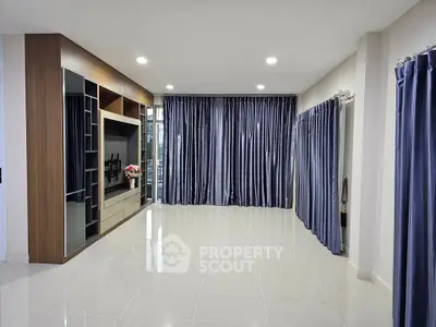 Spacious modern living room with elegant curtains and sleek tile flooring