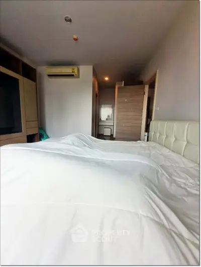 Spacious bedroom with modern decor and air conditioning in a stylish apartment.