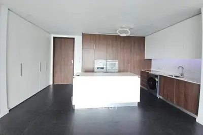 Modern kitchen with sleek cabinetry, island, and built-in appliances in a contemporary apartment.