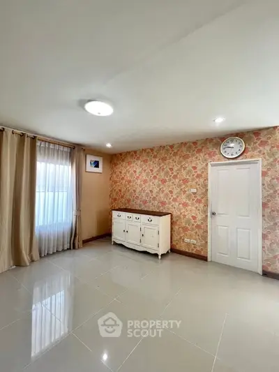 Spacious room with floral wallpaper and elegant curtains, perfect for cozy living.