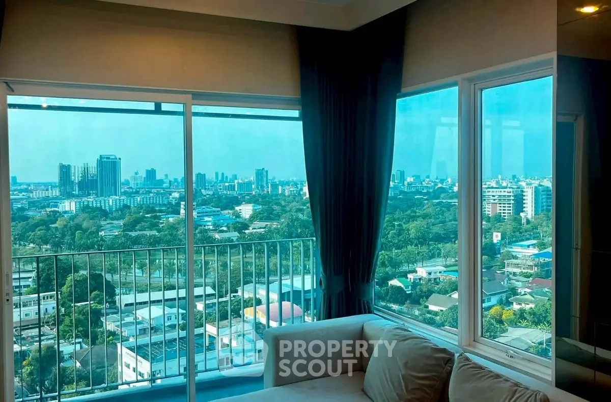 Stunning city view from modern living room with large windows and cozy sofa.