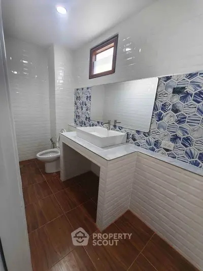 Modern bathroom with stylish tiles and wooden flooring