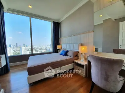 Luxurious bedroom with stunning city view and elegant decor in high-rise apartment.