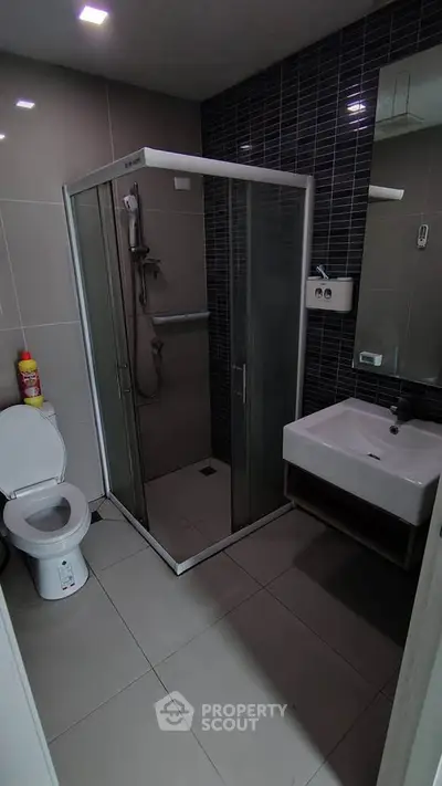 Modern bathroom with sleek shower enclosure and contemporary fixtures.