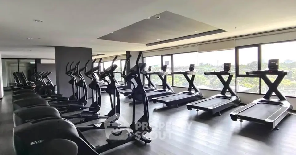 Modern gym with state-of-the-art equipment and panoramic windows offering scenic views.
