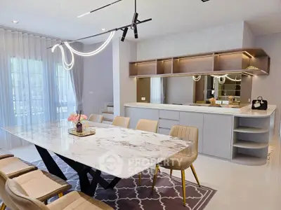 Luxurious modern kitchen with marble dining table and elegant lighting in open layout design.