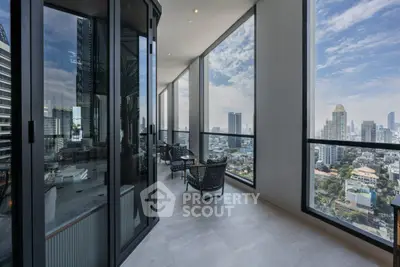 Luxurious high-rise balcony with stunning city skyline views and modern seating area.