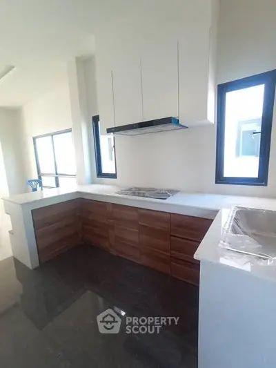 Modern kitchen with sleek cabinetry and built-in stove in a bright, spacious layout.
