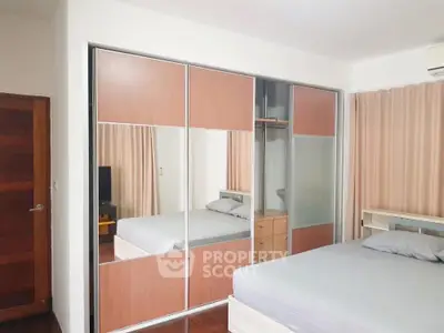 Spacious bedroom with mirrored wardrobe and modern decor