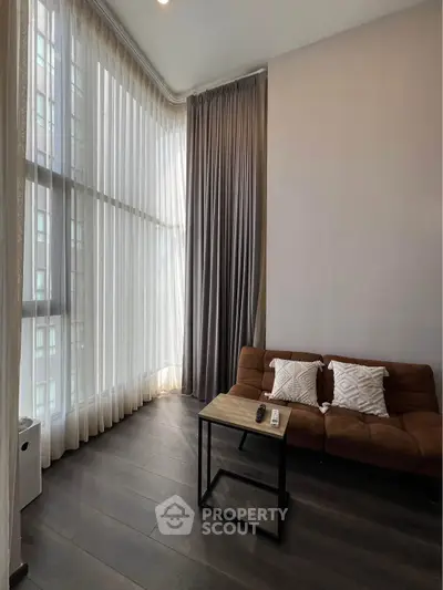Modern living room with high ceilings and floor-to-ceiling windows