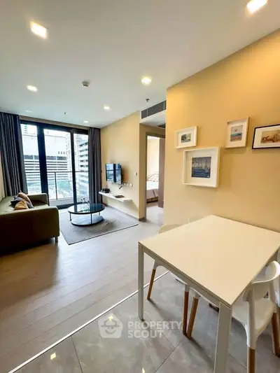 Modern living room with balcony view, open layout and stylish decor in urban apartment.