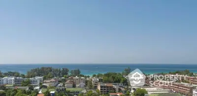 Stunning ocean view from high-rise apartment overlooking lush greenery and coastal skyline.