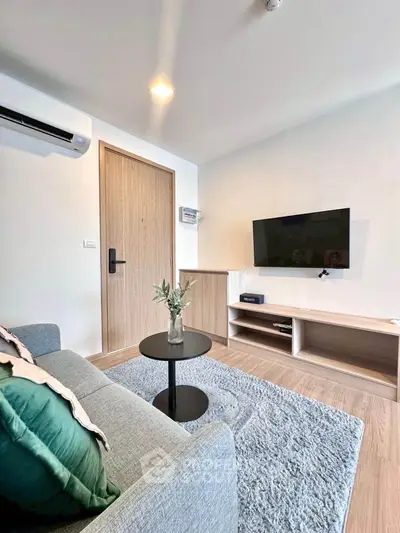 Modern living room with cozy sofa, wall-mounted TV, and stylish decor in a contemporary apartment.